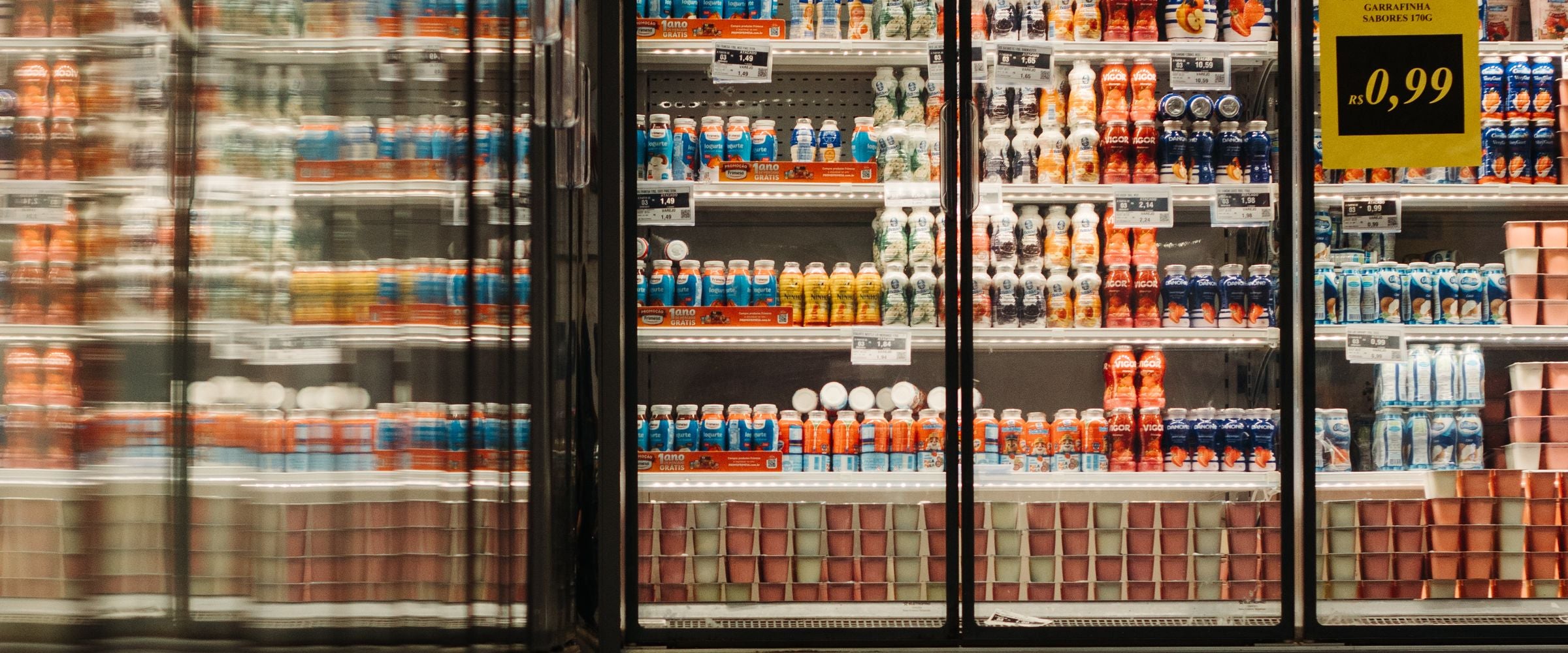 Glass-door merchandiser refrigerators stocked with drinks and groceries