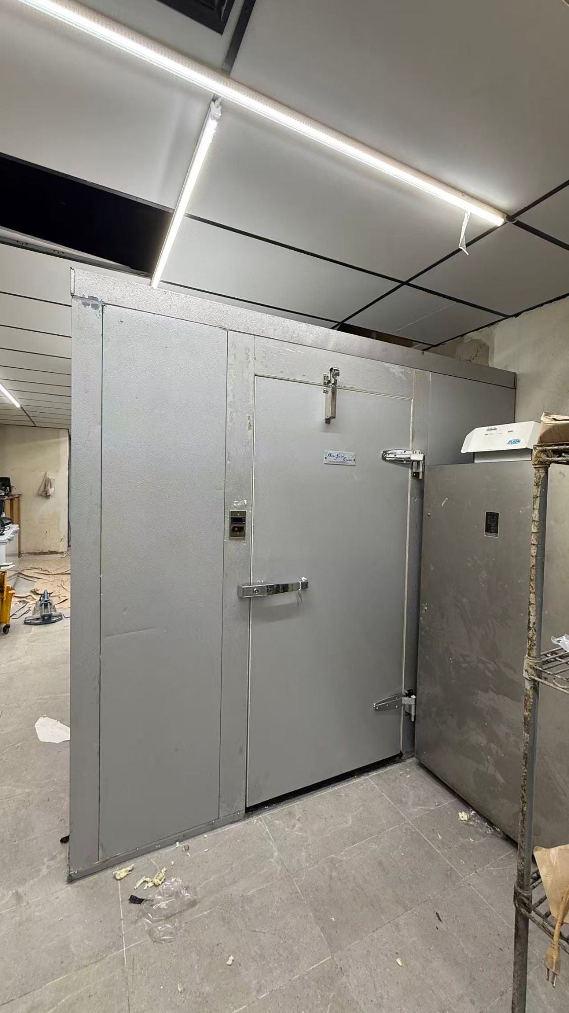 Walk-in cooler installed under drop ceiling in a commercial kitchen, New York