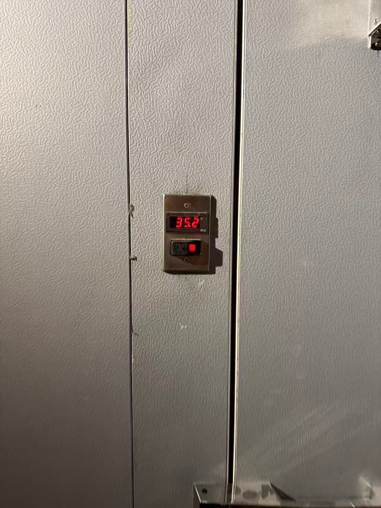 Digital thermostat on walk-in cooler holding 35.2 degrees Fahrenheit